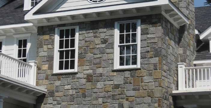 Close-up view of a house exterior featuring a stone-clad wall with two rectangular